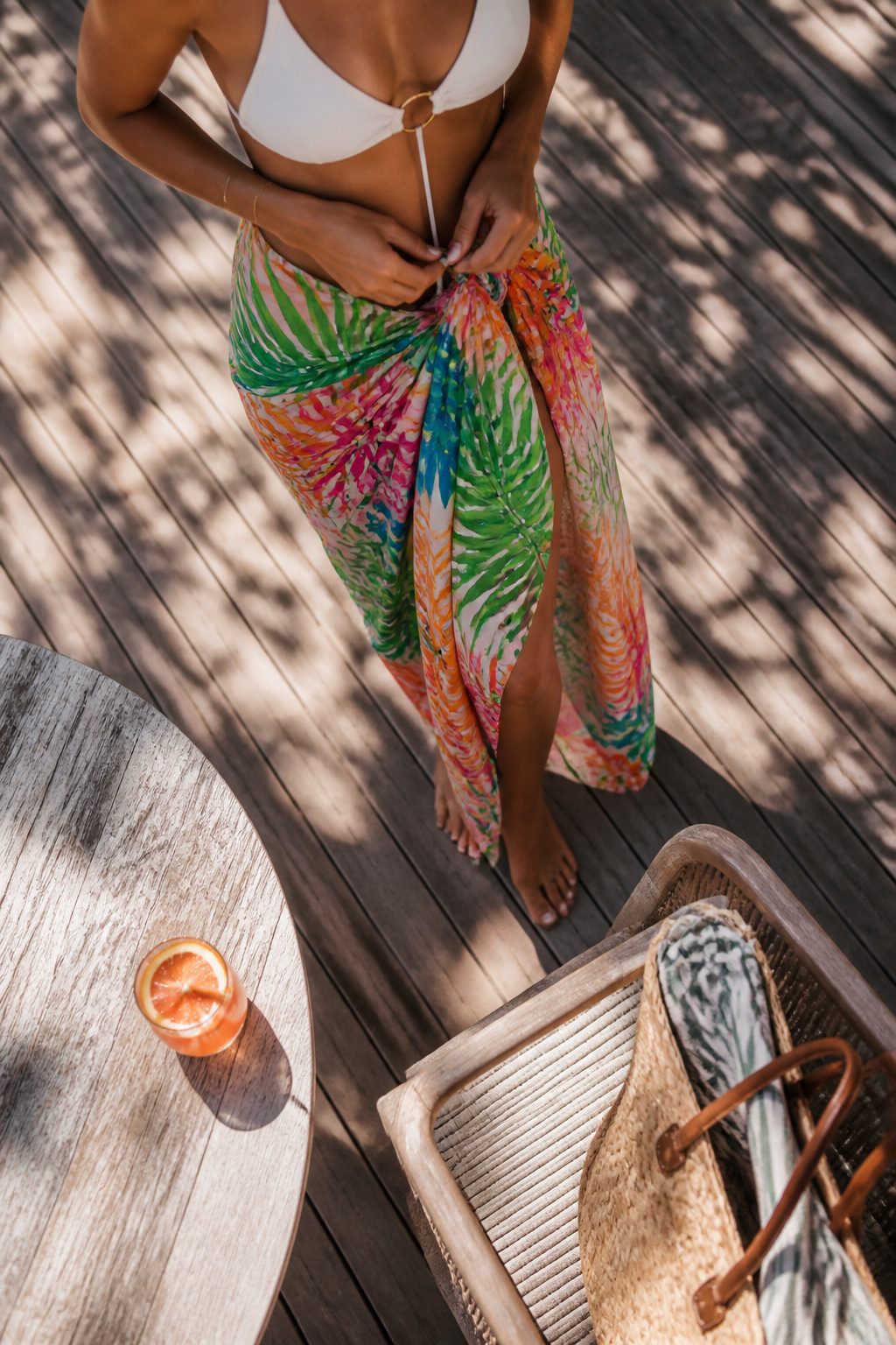 Bathing Suits: Bikinis, One-Pieces, Cover-Ups & Sizing Guide 4 A tied sarong displayed on a wooden rack.
