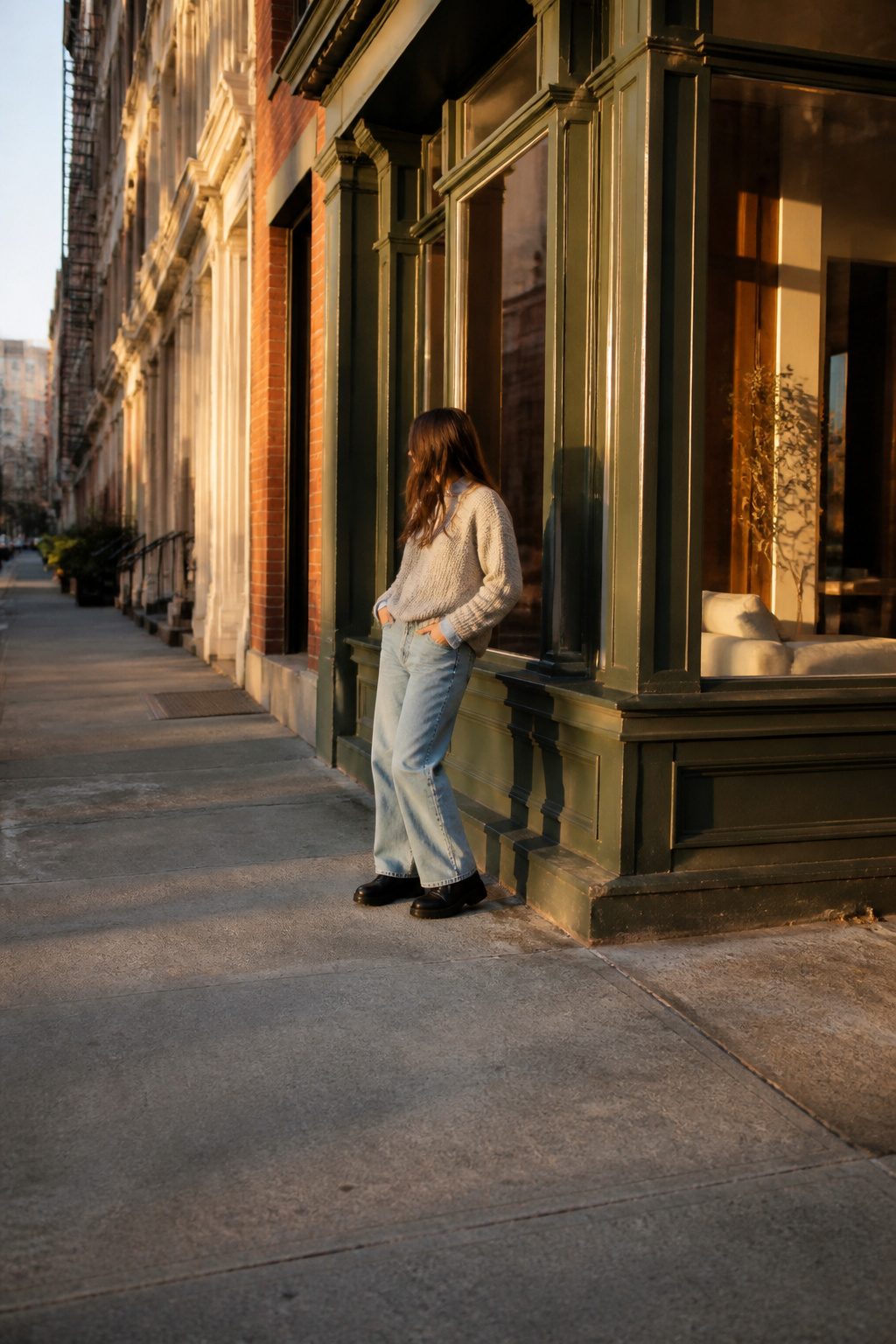 Model showing wide-leg jeans over Chelsea boots in a stylish setting.