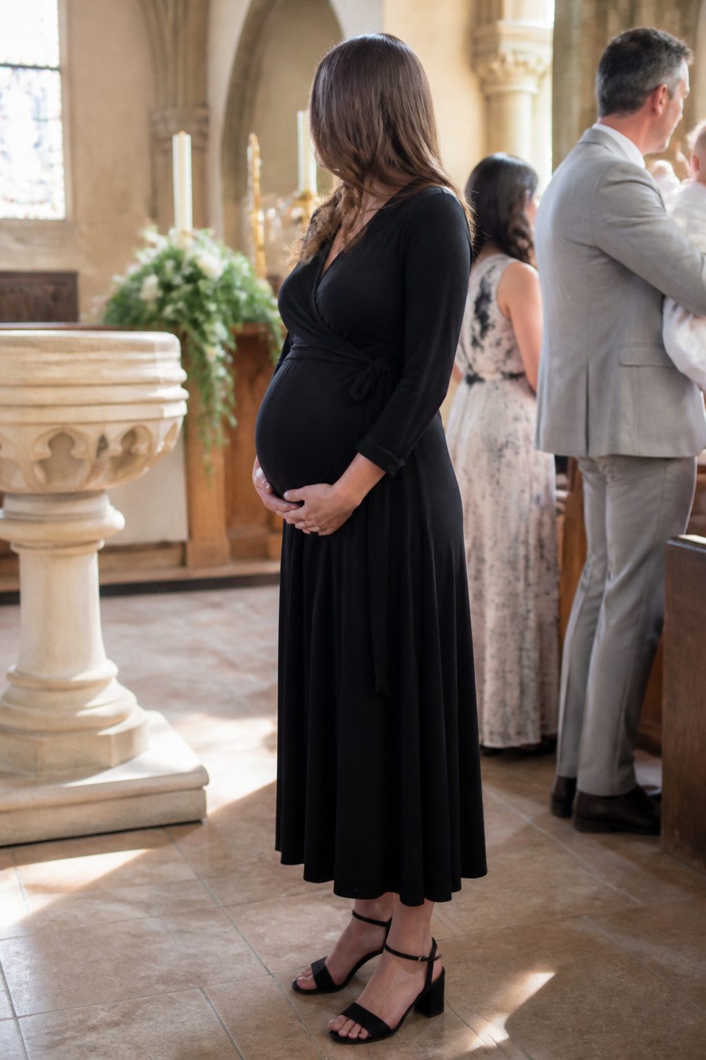 Expectant mother in a nursing dress at a christening ceremony.