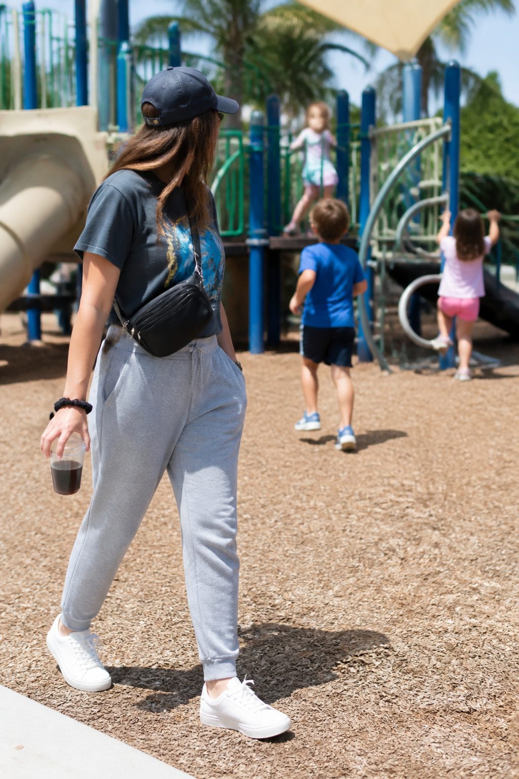 Millennial Mom Outfits: Easy Dressing for Real Days 8 Woman in athleisure pants and a graphic tee at a playground.