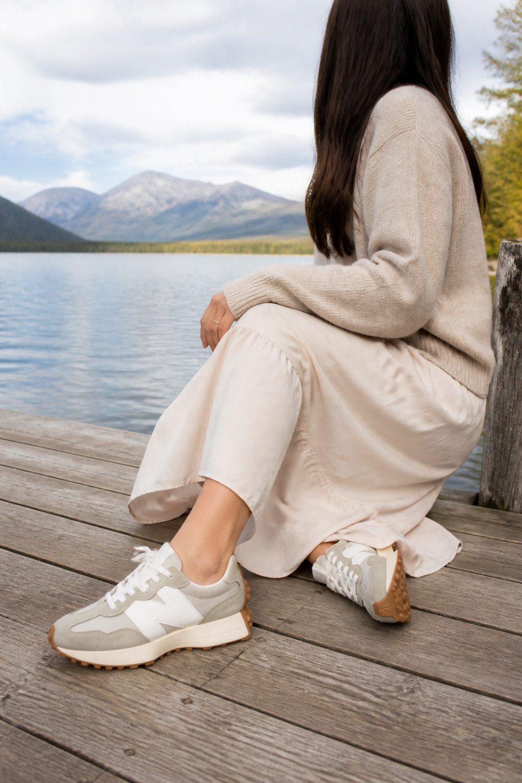 10 Best Sneakers With Dresses for 2026 2 New Balance 327 sneakers on a wooden dock next to a model in a midi dress.